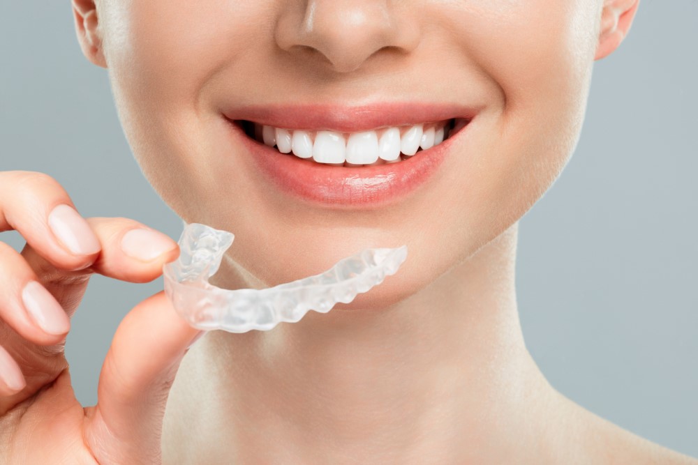 woman holding her aligners