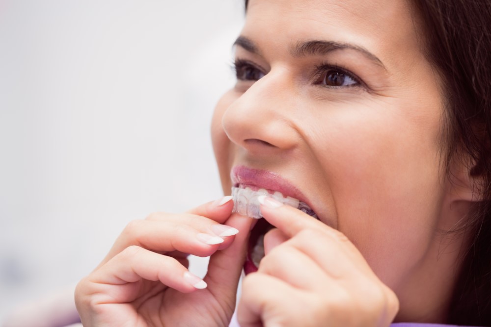 female patient trying to wear retainer